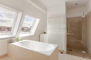 ライプツィヒにある10-12 Personen - Luxus Penthouse Leipzig Zentrum - Thomaskircheの浴槽とシャワー付きの白いバスルーム