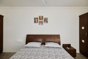 a bedroom with a large bed with a wooden headboard at LakeView Penthouse Room Himayatnagar in Lingampalli