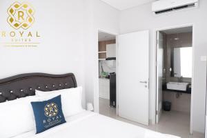 una camera da letto con un letto e un bagno con un lavandino di Royal Suites 2BR at Kalani Tower - Nuvasa Bay a Pulau Nongsa