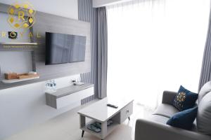 un soggiorno con un divano e una TV di Royal Suites 2BR at Kalani Tower - Nuvasa Bay a Pulau Nongsa