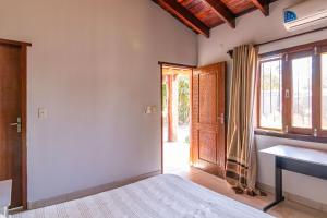 a bedroom with a bed and a window and a door at Rincón del Sol, country charm in the heart of the capital in Asuncion +22 photos