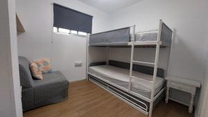 a room with two bunk beds and a couch at Apartamento familiar primera línea de playa in Benidorm