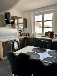 a kitchen with a table and chairs in a kitchen at modernes Apartment mit 2 Schlafzimmer für Monteure und Gäste in Merseburg