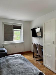 a bedroom with a bed and a desk and a television at modernes Apartment mit 2 Schlafzimmer für Monteure und Gäste in Merseburg