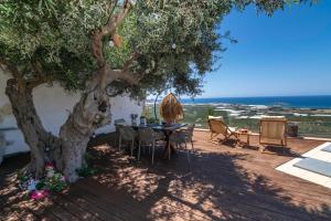 a table and chairs under a tree on a deck at Villa Maritini in Chania Town