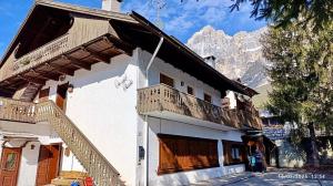 a building with a balcony with a mountain in the background at Relax & Elegance apartment near Cortina in San Vito di Cadore