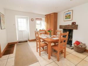 a dining room with a table and chairs and a fireplace at Bridge House in Hawes