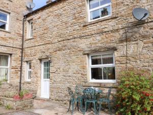 a table and chairs in front of a brick building at Bridge House in Hawes