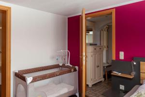 a small room with a bed and a pink wall at Fewo Schuch in Pirna +12 photos