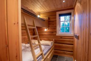 Etagenbett in einem Blockhaus mit einer Leiter in der Unterkunft Trysilfjellet Nord 901 stabur in Trysil
