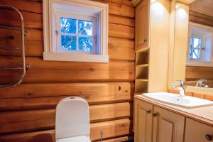 ein Badezimmer mit Holzwänden, einem Waschbecken und einem Fenster in der Unterkunft Trysilfjellet Nord 901 stabur in Trysil