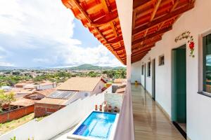 a balcony of a house with a swimming pool at Casa de temporada Âncora dos Sonhos Pirenópolis Goiás in Pirenópolis