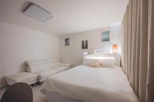 a white bedroom with a bed and a chair at 홍대 stay yoo - Hongdae 3min Station Cozy House in Seoul