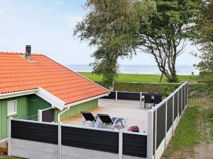 a deck with chairs and a house and the ocean at Seaside Bliss with Spa - By Traum Ferienwohnungen in Otterup