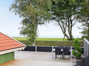 a table and chairs on a deck with a view of the ocean at Seaside Bliss with Spa - By Traum Ferienwohnungen in Otterup +28 photos