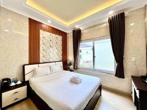 a bedroom with a large bed and a window at Savio Hotel Trieu Viet Vuong in Da Lat