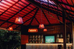 a bar with lights and a tv in a room at Grass Resort and Spa in Nashik