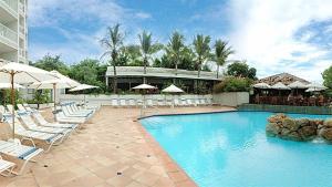 a swimming pool with lounge chairs and umbrellas at Elegant Apartment Lowlands + Pool in Lowlands