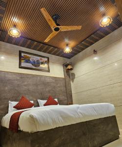 JāmbにあるGhanshyam Hotelのベッドルーム1室(ベッド1台、シーリングファン付)