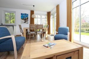 a living room with a table and chairs at Haus Eichkater in Dierhagen