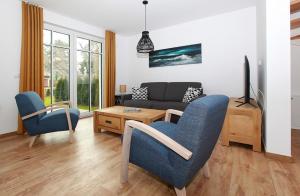 ein Wohnzimmer mit blauen Stühlen und einer Couch in der Unterkunft Haus Eichkater in Dierhagen