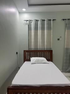 ザンジバルシティにあるChic Central Near Airport Family Houseの大型ベッド1台(シャワー付)が備わる客室です。