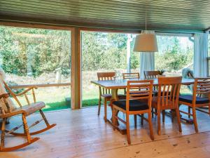 a dining room with a wooden table and chairs at 6 person holiday home in Rømø in Bolilmark