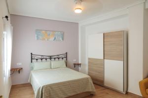 a white bedroom with a bed and a closet at Apartamento Estilo Rustico Buñol - ELPATIO- in Buñol