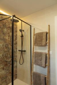 a bathroom with a glass shower with towels at Apartamento Estilo Rustico Buñol - ELPATIO- in Buñol +48 photos