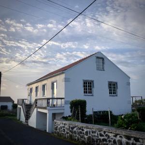 a white house with a staircase in front of it at Casa Ameixa in Lajes das Flores