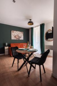 a living room with a table and chairs and a couch at Studio rénové - Accès direct Paris in Montreuil