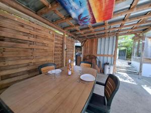 a wooden table with chairs and a wooden wall at Chambre Villa Virginie Confort, Cuisine équipée, WiFi Parking jardin, Idéal couple, famille ou télétravail, Accès rapide Paris, Aéroport d'Orly in Vigneux-sur-Seine