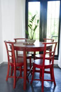 Una mesa de madera con cuatro sillas y una planta encima. en Sureka Home Stay, en Habaraduwa Central