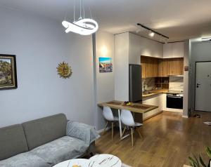 a living room and kitchen with a couch and a table at Starli Apartment - Tirana in Tirana