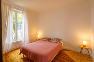 a bedroom with a bed with two lamps and a window at Ker Gaïdic - Proche Plage in Bénodet +6 photos