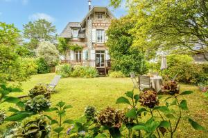 an old house with a table and chairs in the yard at Ker Gaïdic - Proche Plage in Bénodet