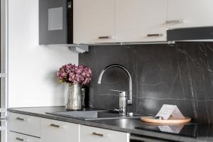 eine Küchentheke mit einer Spüle und einer Vase aus Blumen in der Unterkunft Vapari - Tampere Soccer Stadium by Come in! in Tampere + 58 Fotos