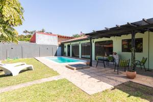a backyard with a swimming pool and a house at Rincón del Sol, country charm in the heart of the capital in Asuncion