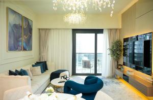 ein Wohnzimmer mit einem weißen Sofa und blauen Stühlen in der Unterkunft Iconic Burj Khalifa, Fountain Views, Luxury 2BR in Sabkhah