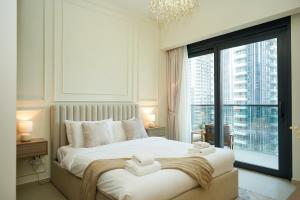 ein Schlafzimmer mit einem großen Bett und einem großen Fenster in der Unterkunft Iconic Burj Khalifa, Fountain Views, Luxury 2BR in Sabkhah + 24 Fotos