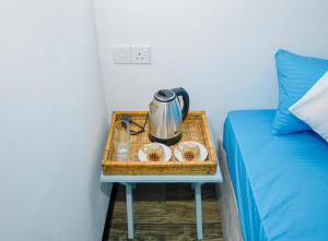a tray with a tea kettle and plates on a bed at Ramya Ru Nature Resort in Galle