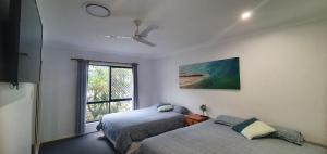 a bedroom with two beds and a window at Sandys On Cypress - Rainbow Beach, pets welcome in Rainbow Beach