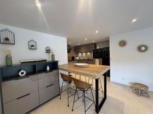 a kitchen with a wooden table and chairs in it at Superbe 2P Terrasse Proche Plage à 2 min in Saint-Raphaël
