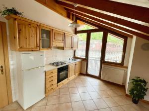 a kitchen with wooden cabinets and a white refrigerator at La Sghirata in Venas