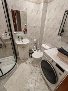 a bathroom with a toilet and a sink and a shower at Apartament na Placu Swietego Sebastiana in Opole +8 photos