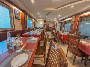 a dining room with tables and chairs in a restaurant at Rare Himalayas De Regency Pelling in Pelling