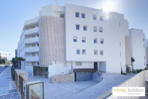 a white building next to a tall building at Homity Holidays - Playa Granada - Mar de Fabiola in Motril