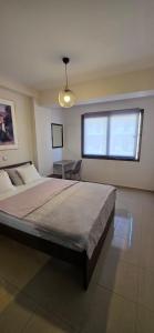 a bedroom with a large bed and a table at Your Home in Xanthi