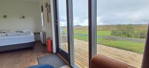 Zimmer mit einem Bett und einer Glasschiebetür in der Unterkunft Guesthouse Klambrasel in Skogar