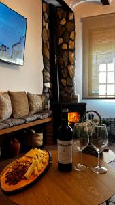 a table with a bottle of wine and two wine glasses at La Casa de la Abuela in Higueruela